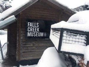 One end of the Falls Creek Museum building exterior shot showing museum name and snow covered area