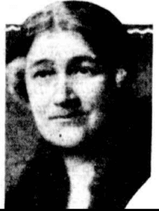 Close up black and white portrait of a woman. Photo quality of poor and a little grainy but we can see she has strong eyebrows and a mole on her chin.